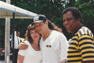 Neal McCoy hugs a female fan for a photograph while Charley Pride smiles