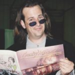 Robert Reynolds pretending to read an issue of Country Wave Magazine