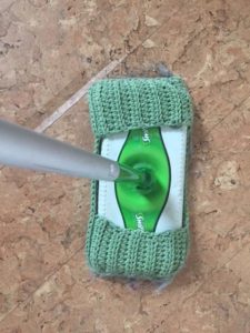 Green knitted piece fits over the Swiffer head just like a pad but it washable and reusable