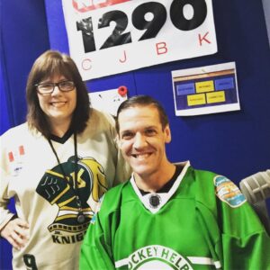 Ken and I wearing London Knights jerseys, posing in the studio in front of the CJBK sign