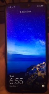My new phone in my h and with a bright blue ocean and sky scene on the screen