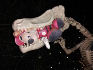 MIckey Mouse caught in the jaws of a dinosaur