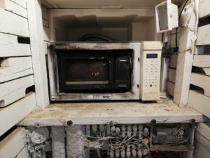 Small microwave inside a larger microwave. Both are burned and melted a bit