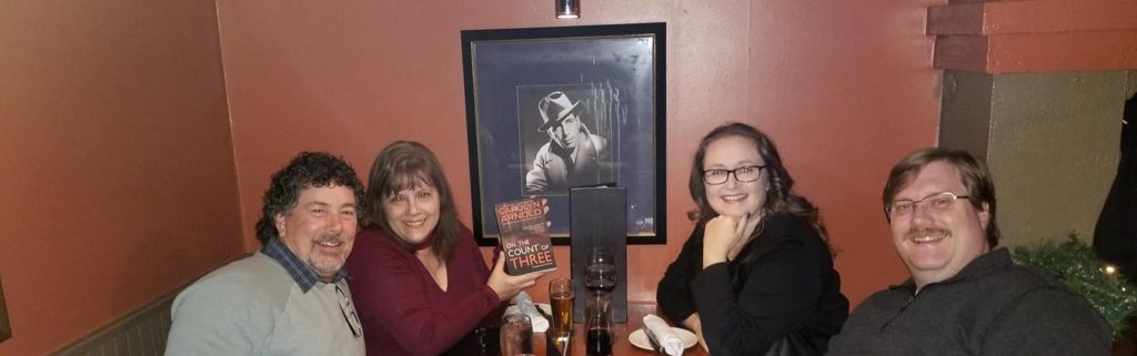 The four of us at our table at the Keg in front of picture of Humphrey Bogart. I'm holding up a paperback of Carolyn's new book.