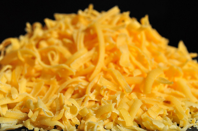A mound of shredded cheddar cheese.