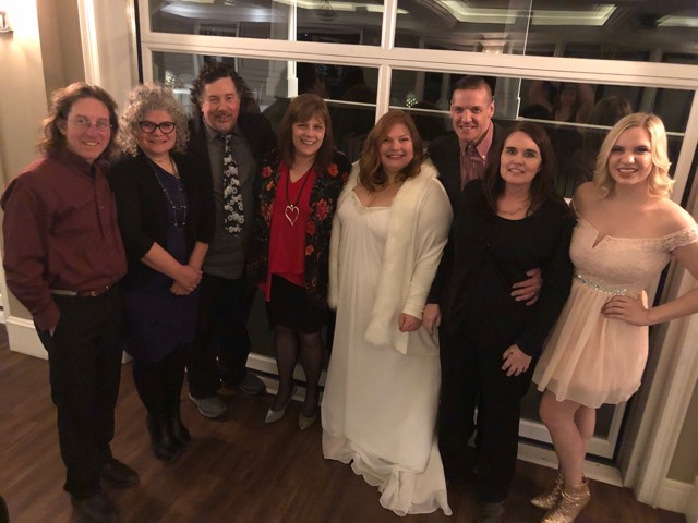 Bride Loreena in a beautiful, long white gown and faux-fur coat surrounded by producer Ryan and his wife Wendy, Derek and me, Ken and his wife Nora, and young Sara MeshMesh, the current newscaster on CJBK.