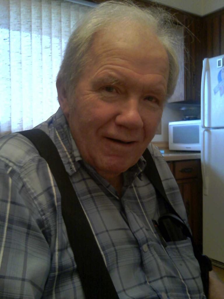 Photo of my Dad smiling and wearing his trademark plaid short-sleeved shirt and suspenders