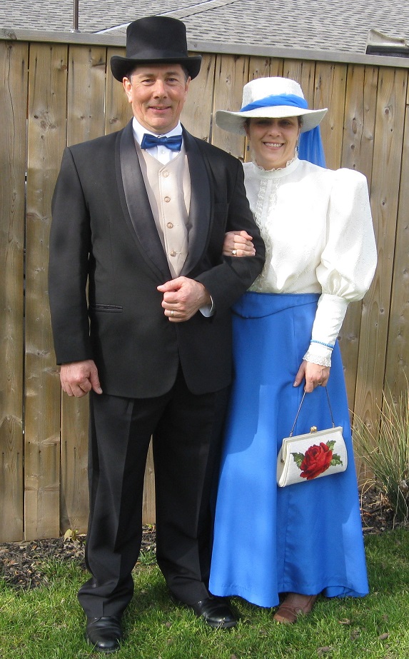 Derek and I posing outside. He's wearing a tux and top hat and I'm in a bright blue skirt, white blouse and white and blue hat, appropriate for 1912.