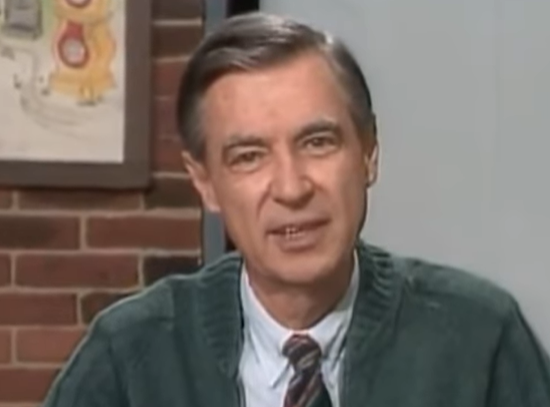 screen grab of Mr Rogers looking into the camera. He's wearing a grey cardigan