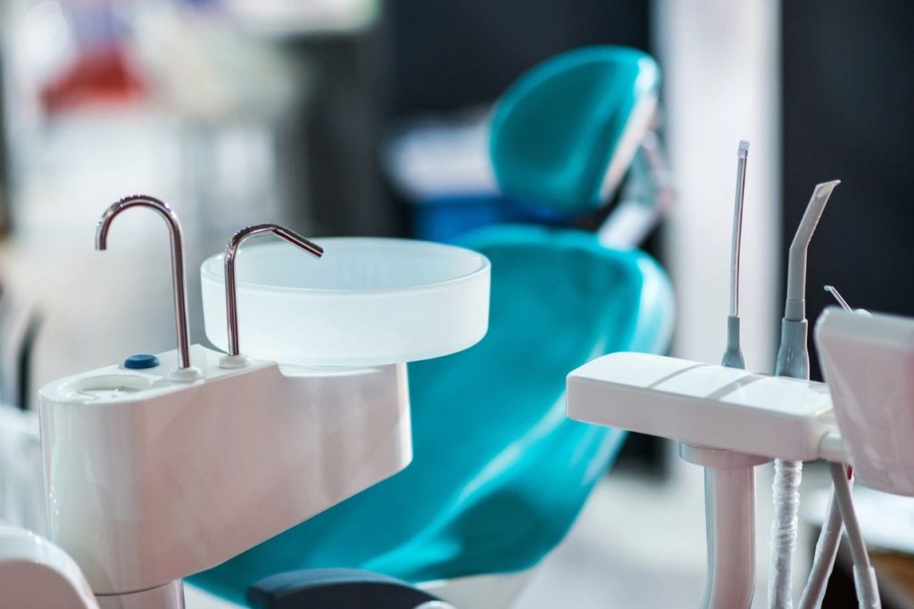 a view inside a dental exam room with the little sink and patient chair visible