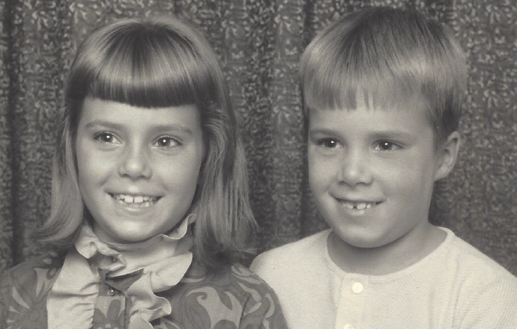 A black and white photo of Kevin and I as little kids, all dressed up and smiling in a professional portrait.
