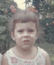 Me, about age 4, looking into the camera. My bangs are a wavy line with a couple of longer sections here and there. 