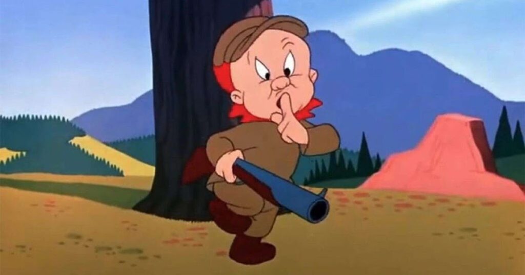 Elmer Fudd holding his gun with one hand and making the Shhhhh signal with the other