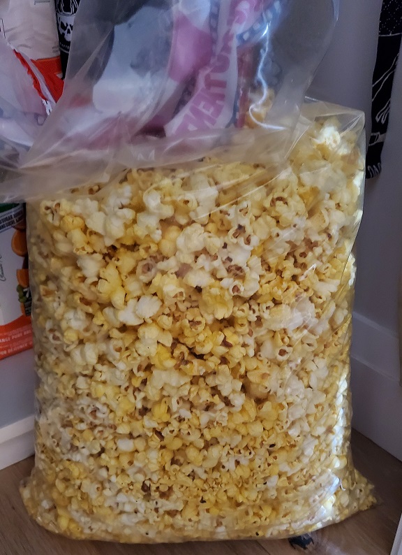 Huge bag of popcorn sitting on the pantry floor.