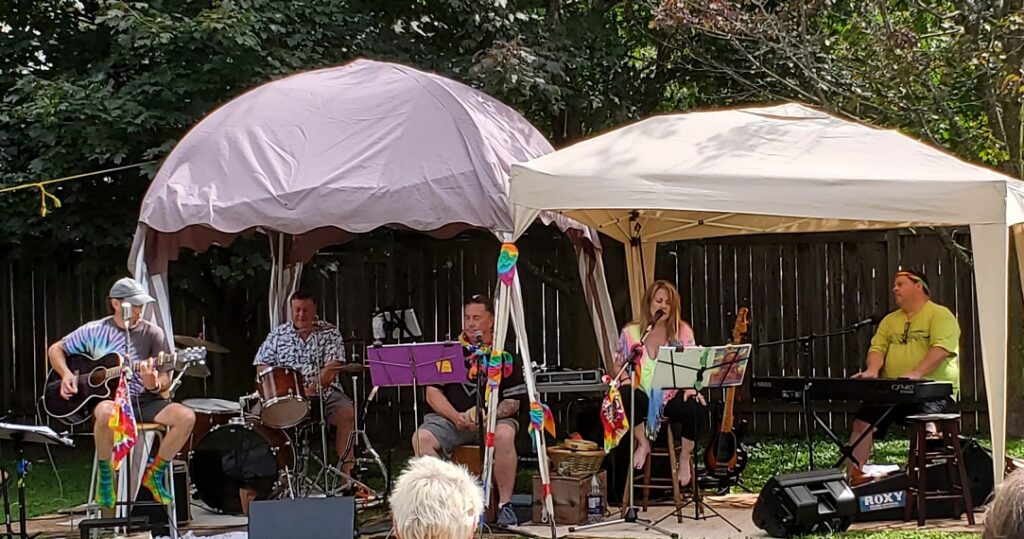 The five siblings, all dressed in bright colours and tie-die prints, performing under two canvas tents. 