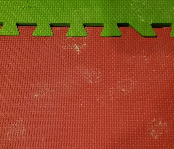a red mat with several paw prints made of flour on it