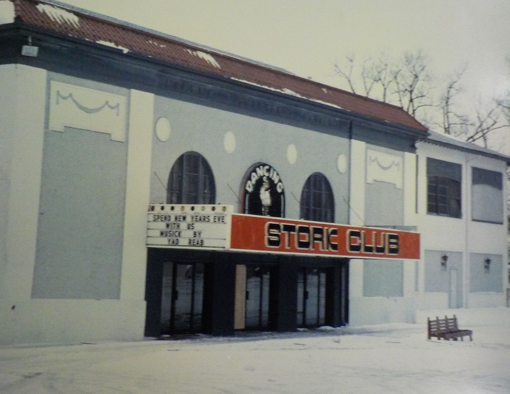 Front of the Stork Club. Long white building with a red sign above the wide entrance