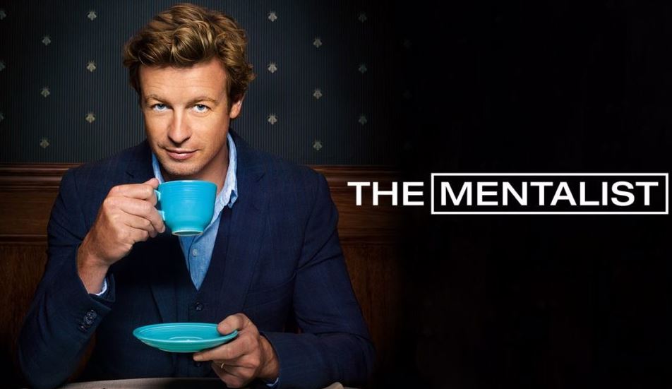 Promo shot for The Mentalist has title in white lettering on the right. On the left, Simon Baker holds his teacup and saucer while he looks into the camera.