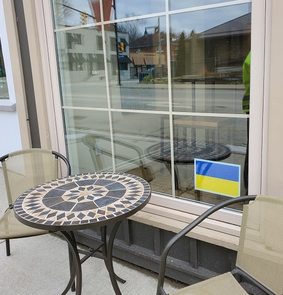 Window of the Harbour Merchant Coffee Co has a blue and yellow decal on it in support of Ukraine