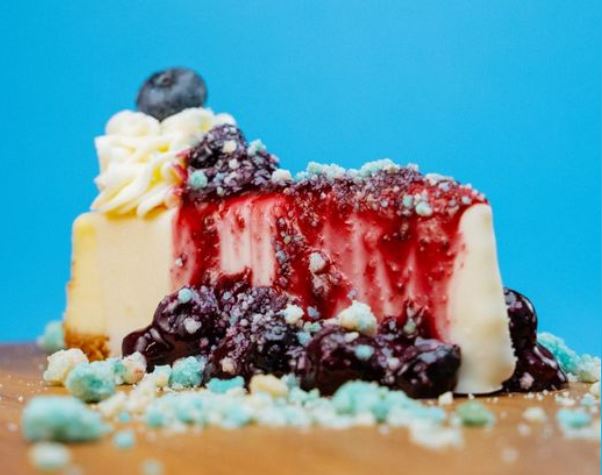 A piece of cheesecake slathered in blueberry sauce.