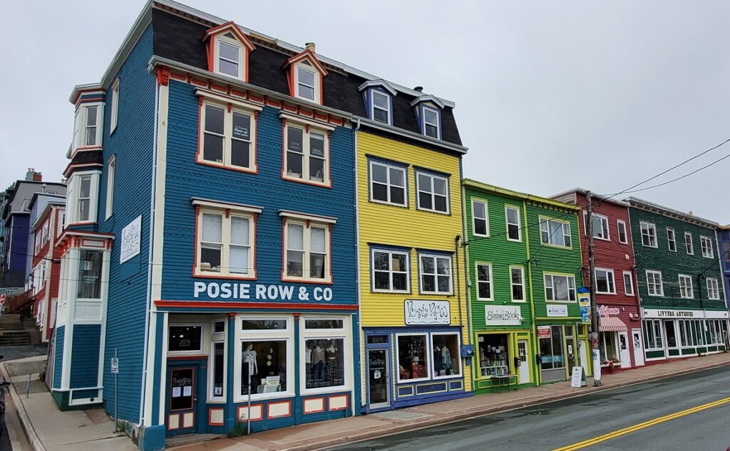 A row of so-called salt-box houses turned into retail stores in St. John's Newfoundland. Each one is a different, vibrant colour. Blue, yellow, green, etc. 