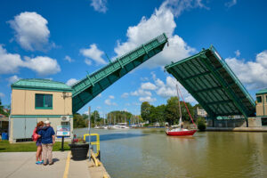 the lift bridge rises to allow a boat to pass beneath it
