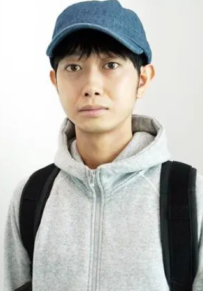 young looking Japanese man wearing a hoodie, ball cap and with a knapsack on him