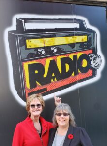 Erin and I posing below a street mural that reads RADIO on Queen St. W.