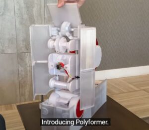 screen shot of the Polyformer machine. It's about a foot tall, white with red parts, and looks almost like a toy.