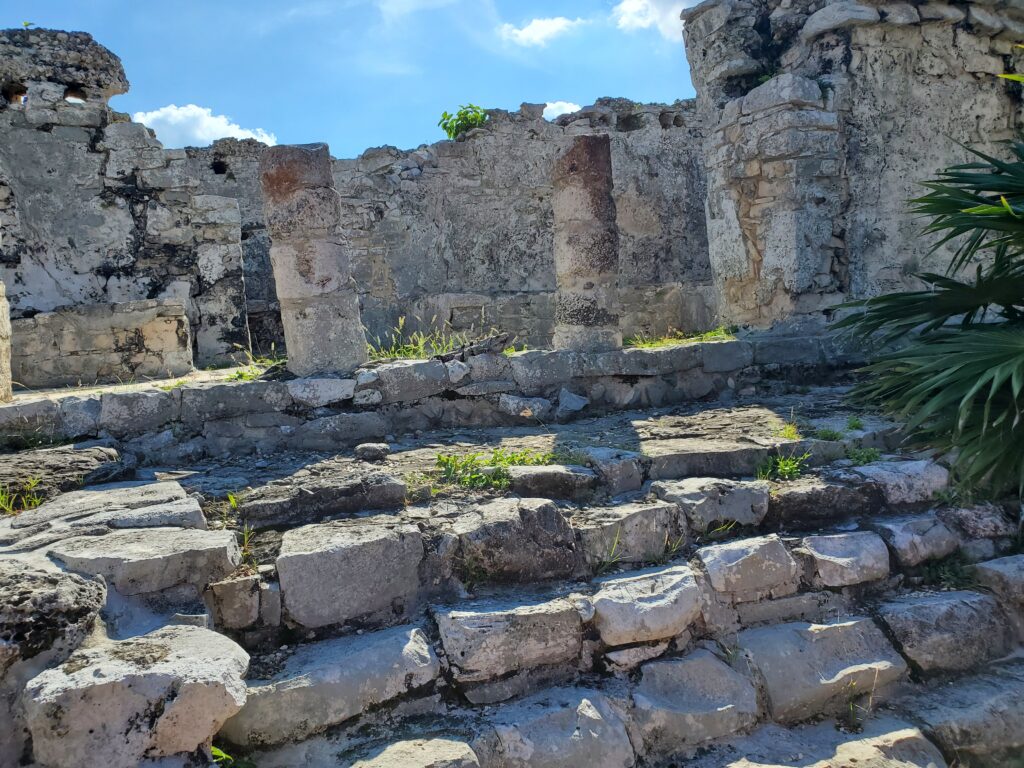 Thousand-year-old ruins at Tulum. Crude looking steps, columns, and walls, in various levels of decay.