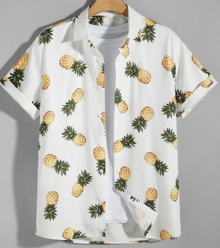 White men's short-sleeved shirt with yellow and green pineapples on it, including some upside down.