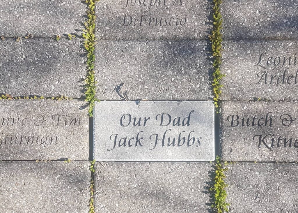 Rectangular brick walkway with a brick in the centre that reads, Our Dad Jack Hubbs.