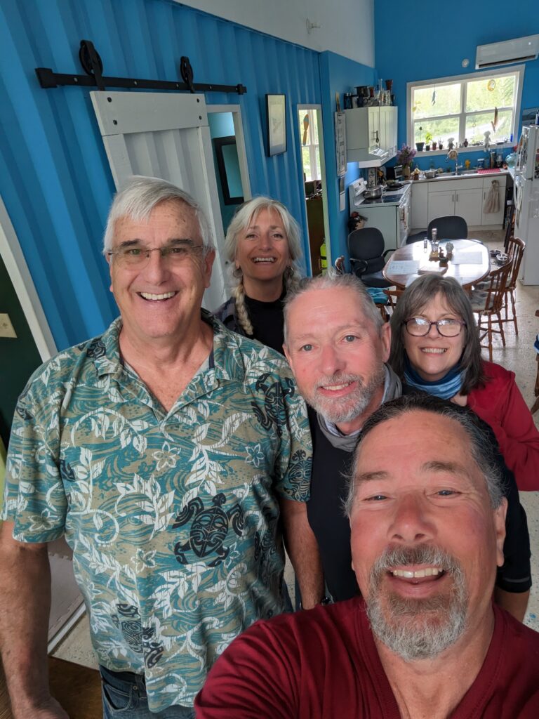 Five of us in varying depths of field as we attempt a selfie! Silver-haired Roy in a tropical shirt is in front. Derek, Tam, Monique and I surround him.