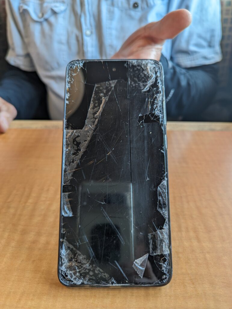 Close-up of a ruined iPhone with cracks, and tire markes on it. 