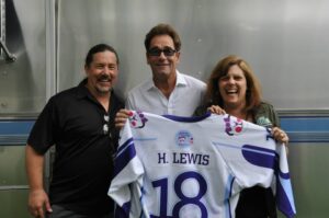 Derek and I flank Huey Lewis as he holds a jersey with his name on the back.