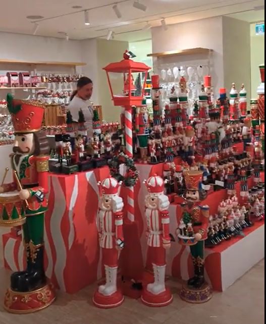 Derek looking over a huge display of bright red, white and green nutcrackers ranging from four feet tall to salt-and-pepper shaker size. 