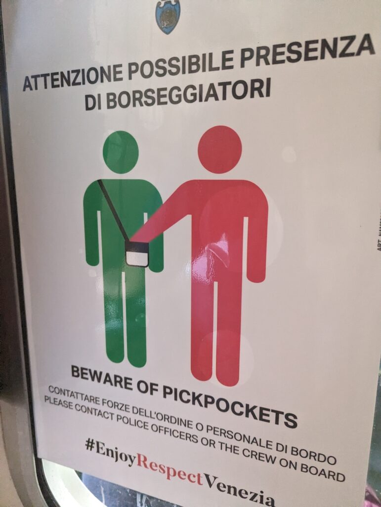 A sign in Italian on the water bus in Venice that warns of pickpockets and says to contact police if someone robs you. 