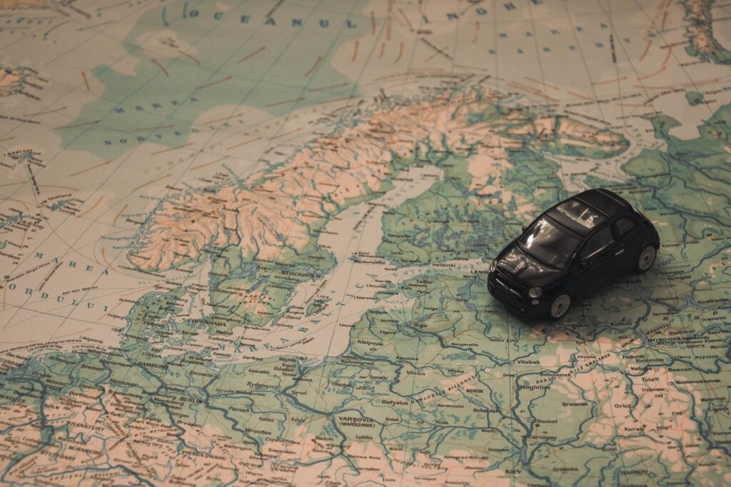 black toy car on world map paper