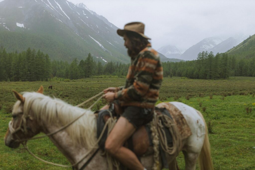 man riding a horse in the grass valley