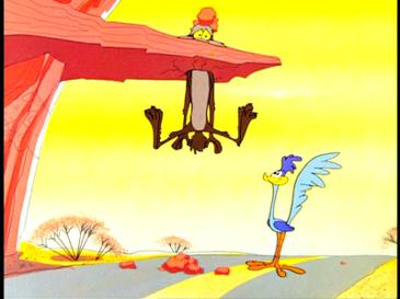 Wile E coyote with his head through a cliff over a highway, as the road runner looks up at him