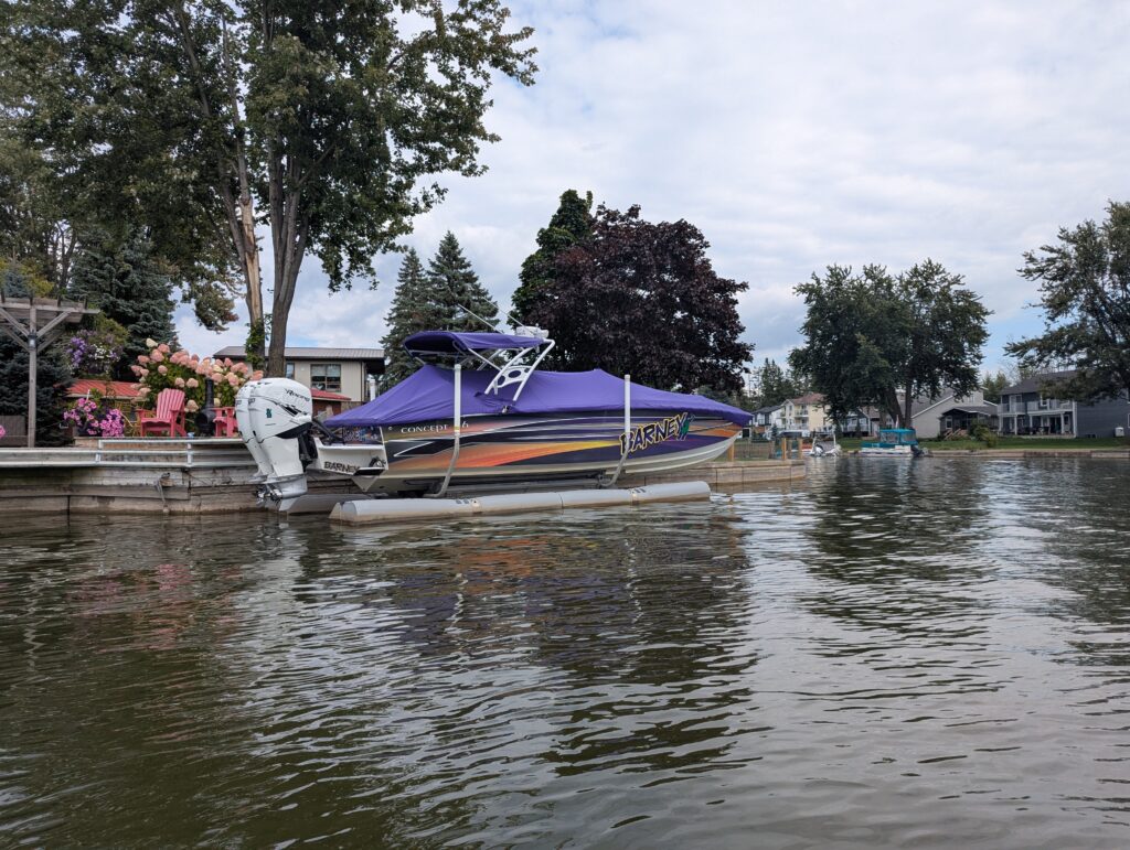 Purple speedboat named Barney completel with a giant sticker of the purple dinosaur on its side.