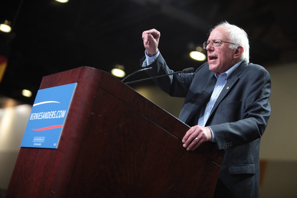 Bernie Sanders making a point during a speech at a podium