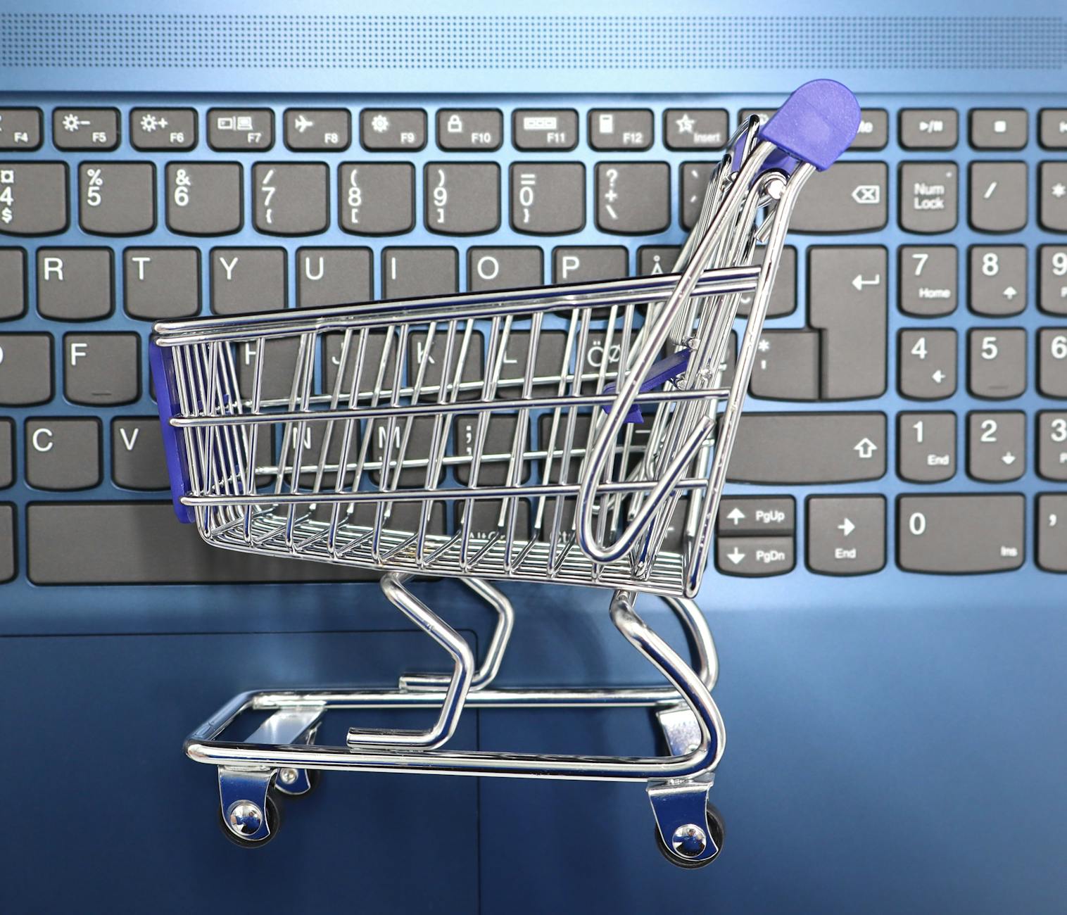 mini shopping cart on laptop keyboard e commerce concept