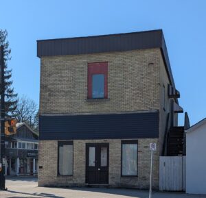 the same building sits vacant with windows papered over