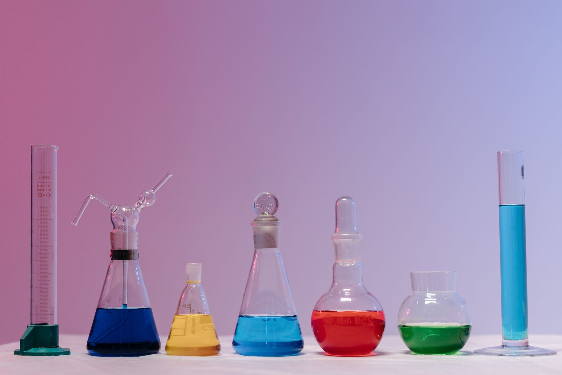 different laboratory glassware with colored liquid