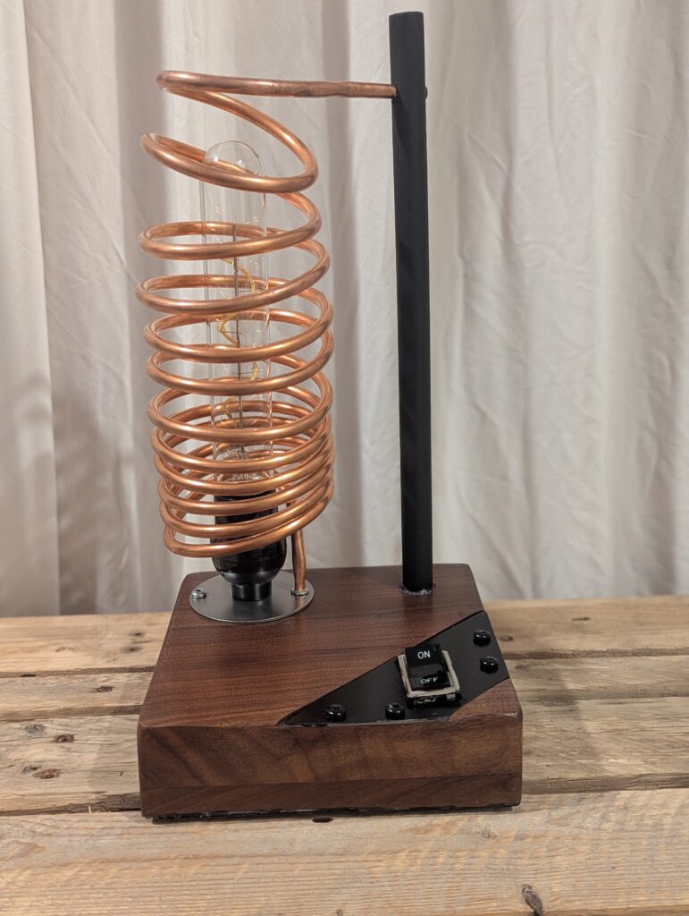 A copper coil lamp on a beautiful piece of refinished maple.