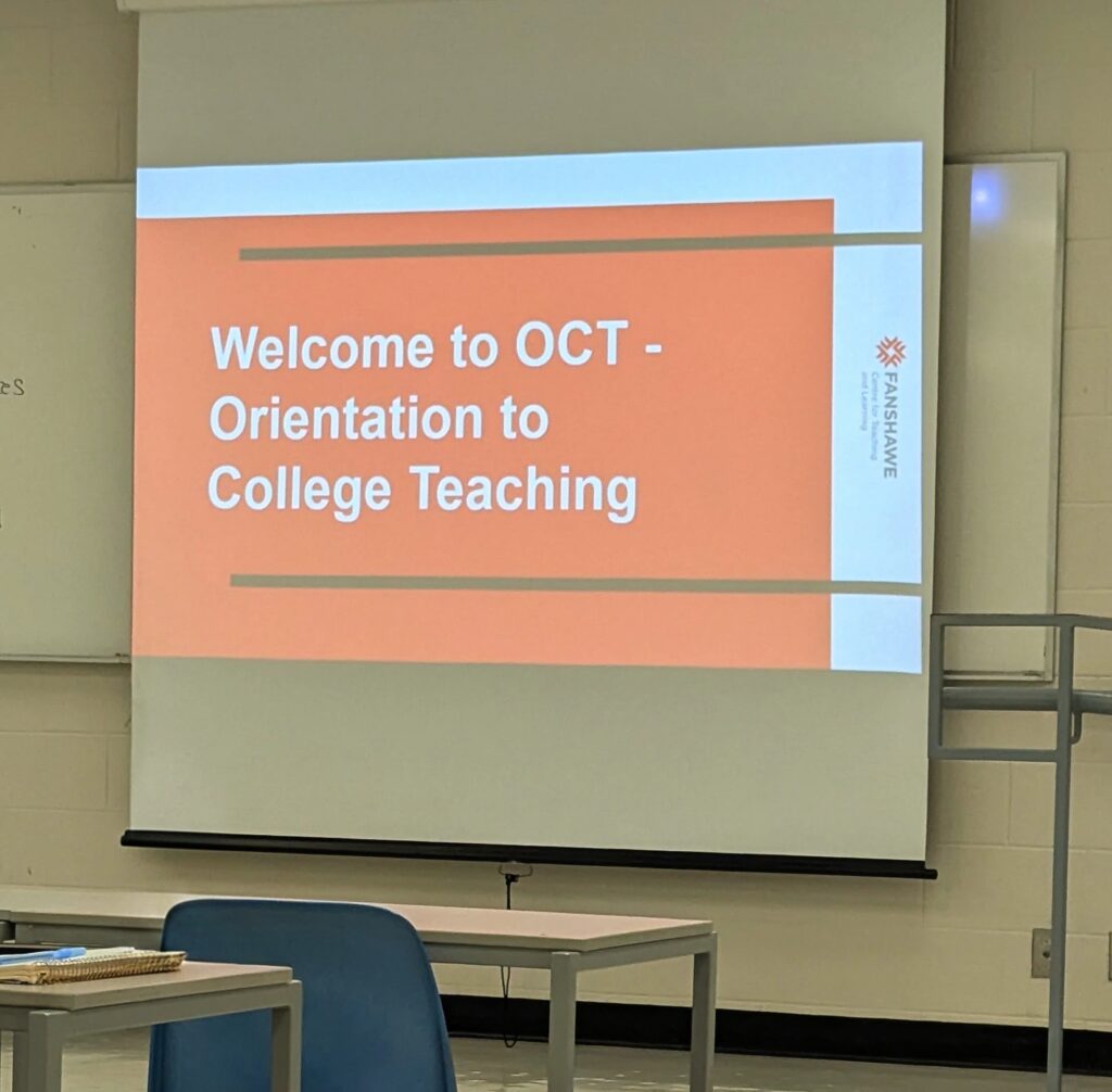 Orange slide projected on to a large screen that has white lettering that reads, Welcome to OCT: Orientation to College Teaching.