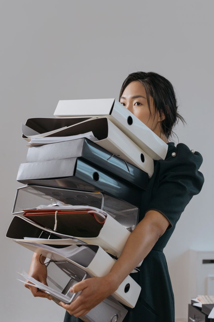a woman holding a pile of file folders